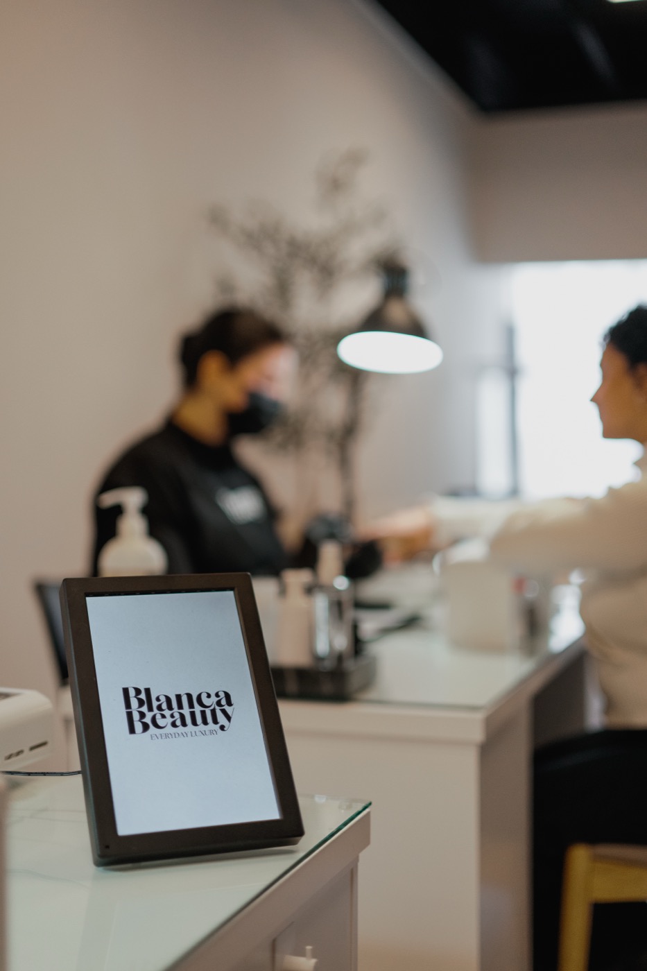 Blanca Beauty Everyday Luxury tagline displayed on a tablet at the manicure station