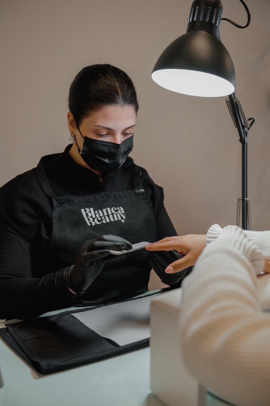 A Blanca nail artist filing a client's nails