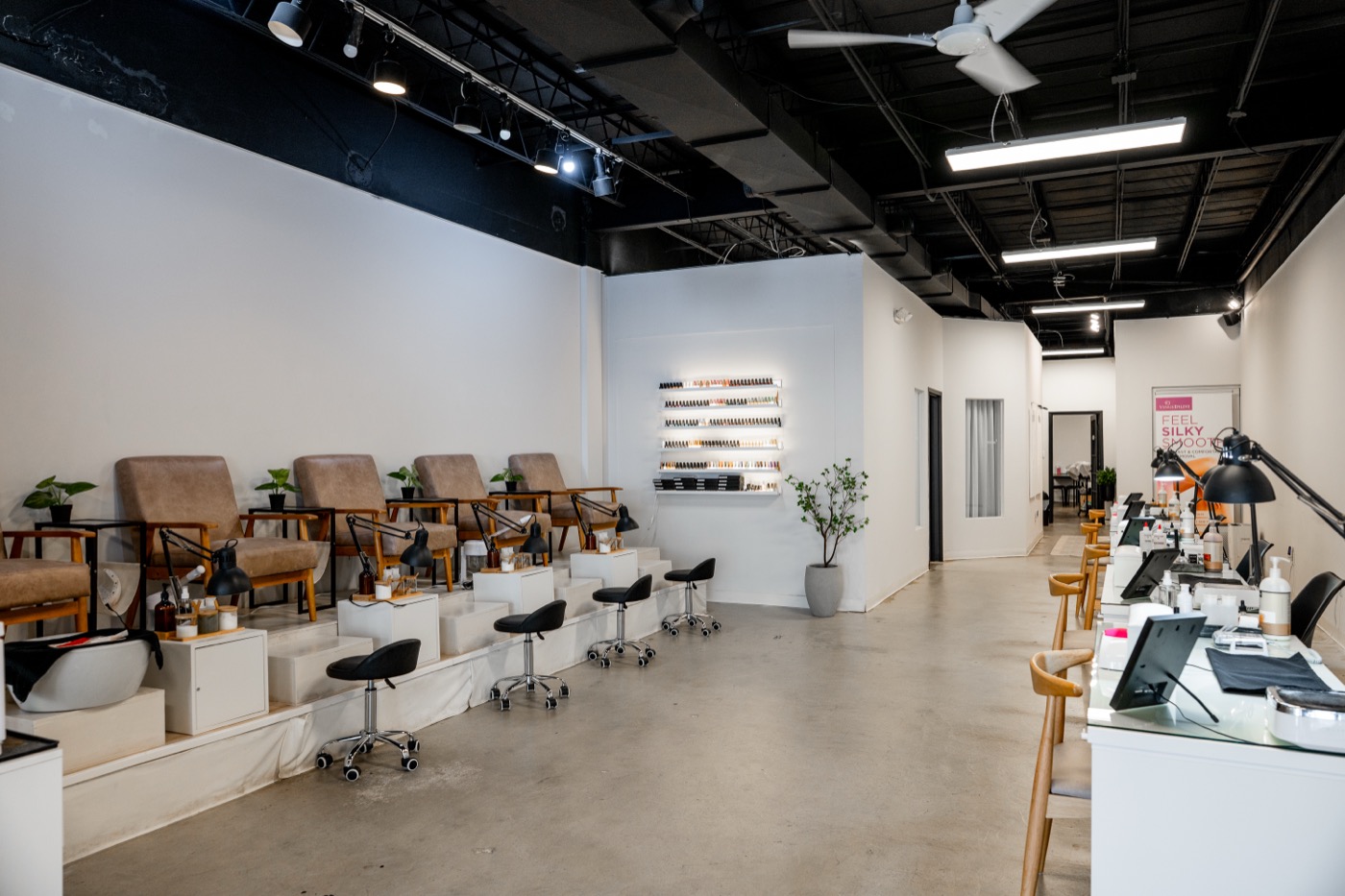 The Blanca pedi room, leather pedicure chairs, polish wall, plants, soft daylight