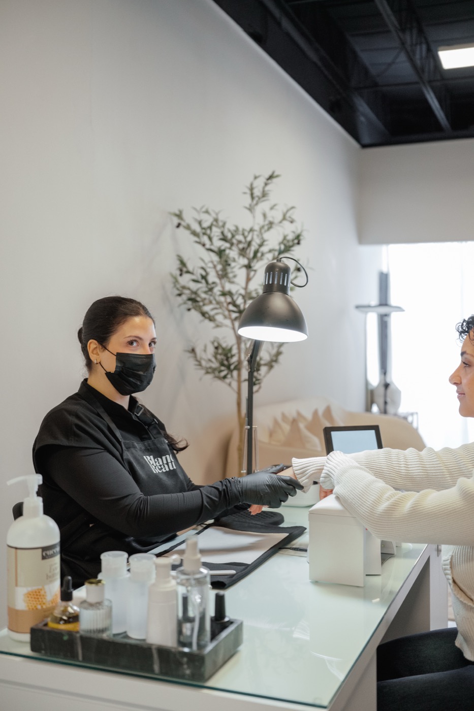Manicurist with a client at the station in the Blanca Beauty Bar studio
