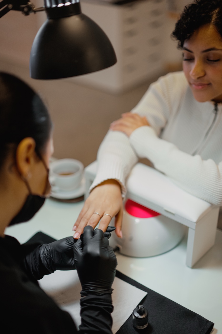 Red gel polish being applied during a Russian manicure